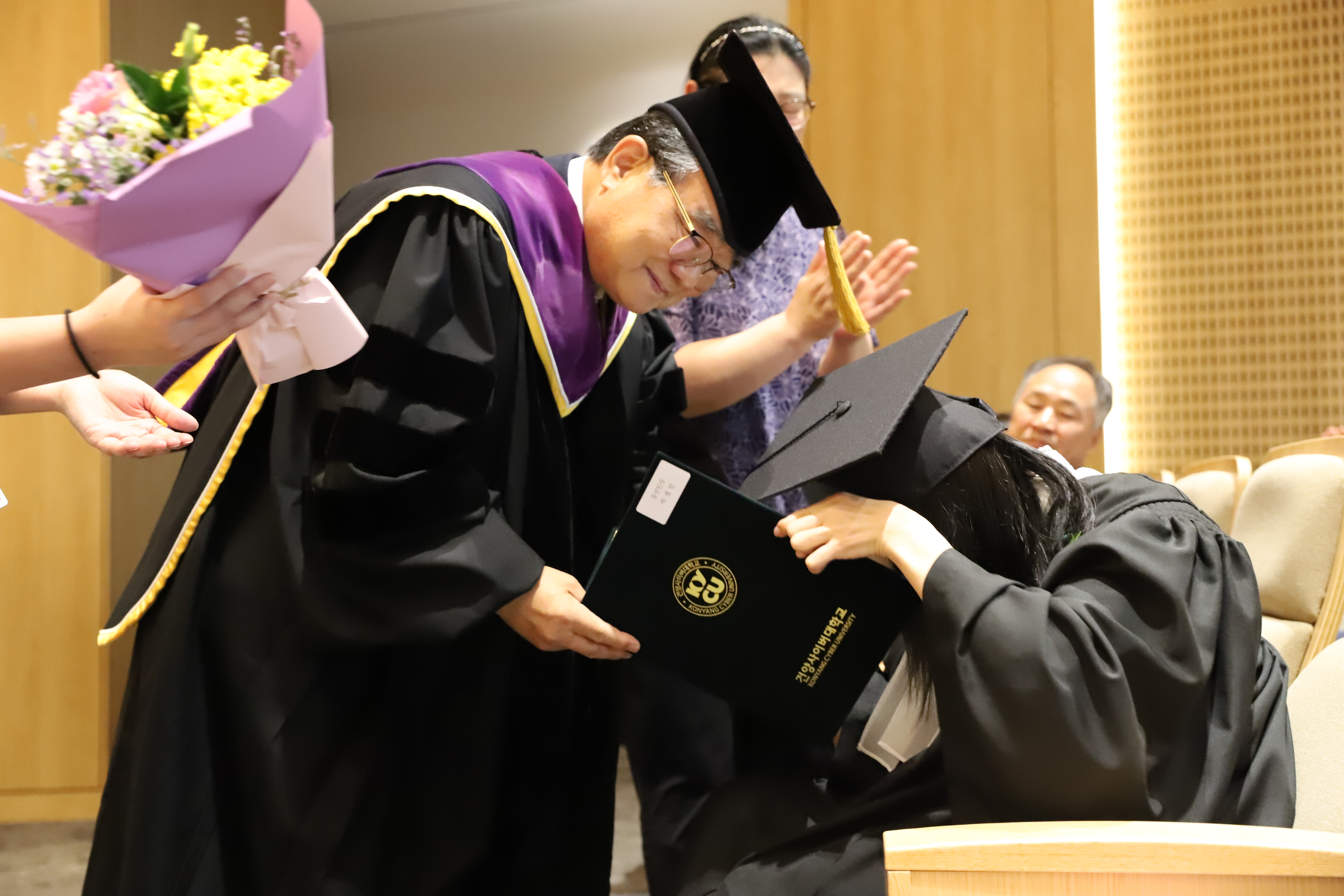 이동진 총장이 몸이 불편한 학생에게 단상 아래에서 학위증을 수여하는 모습